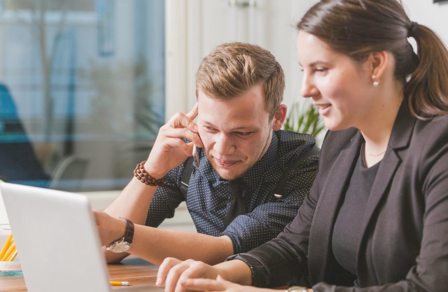 Espace de travail avec documents financiers et ordinateur portable montrant une interface de gestion budgétaire